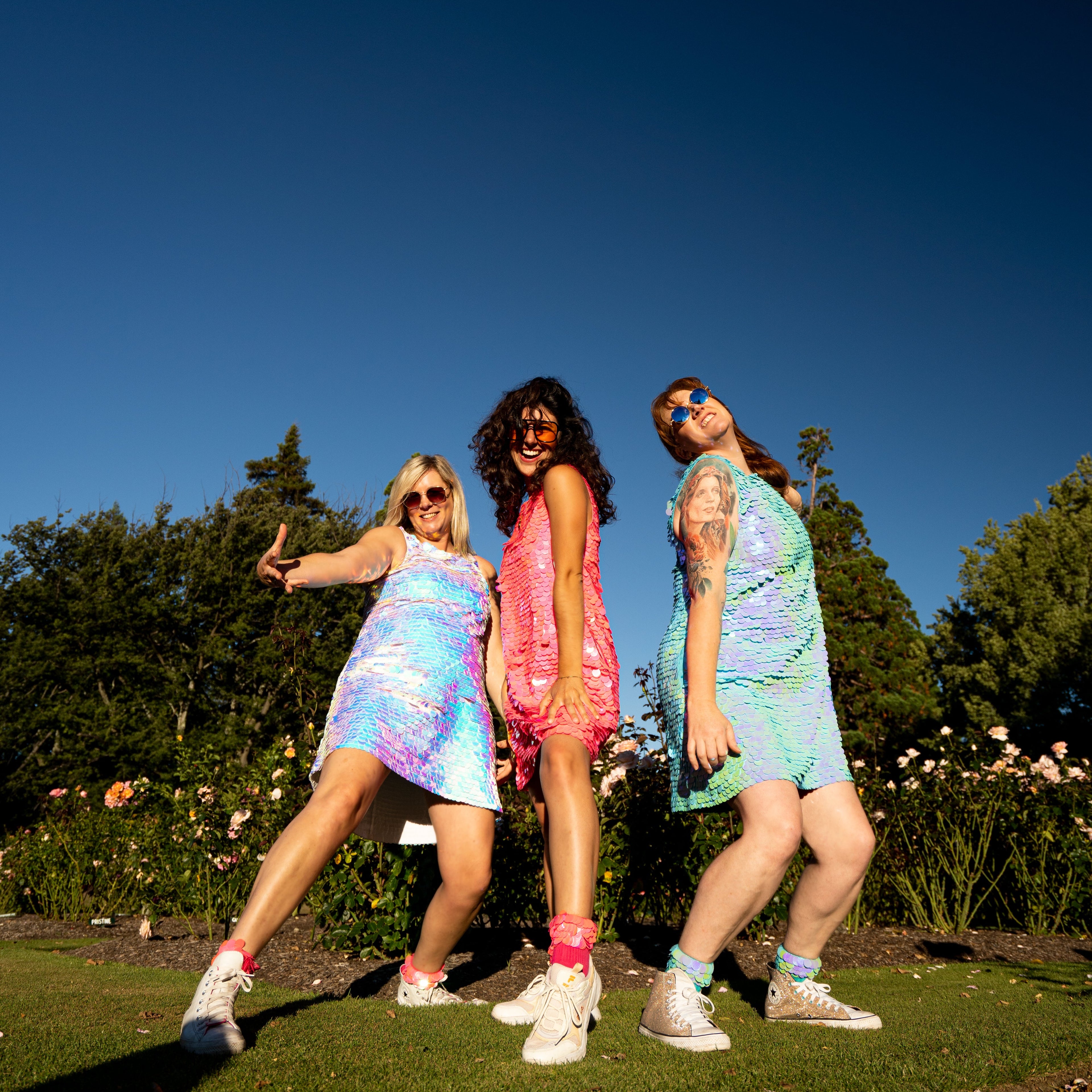 three people in sequin festival dresses and sequin socks for party wear

